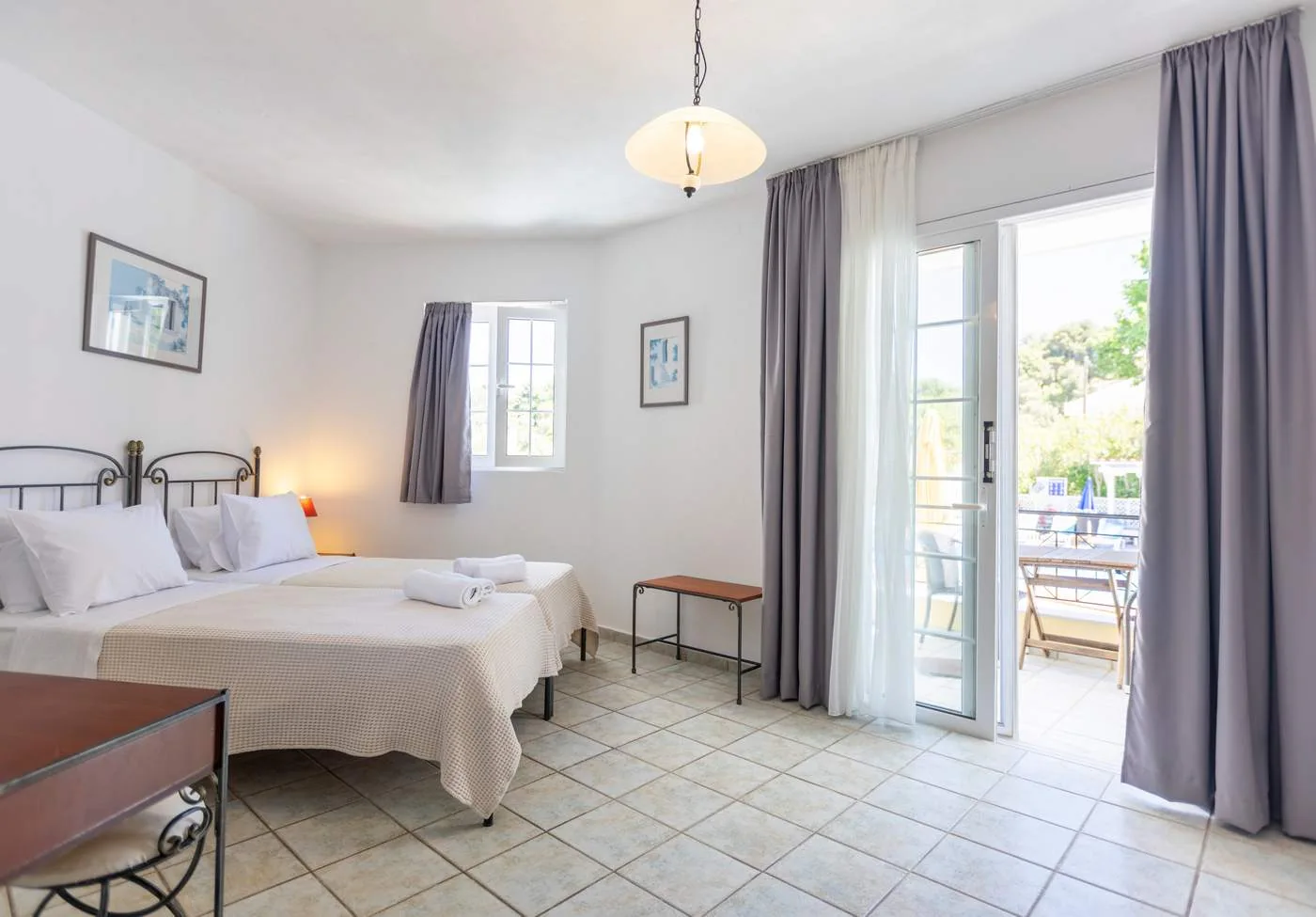 Bright studio with twin beds and wide doors opening onto the balcony